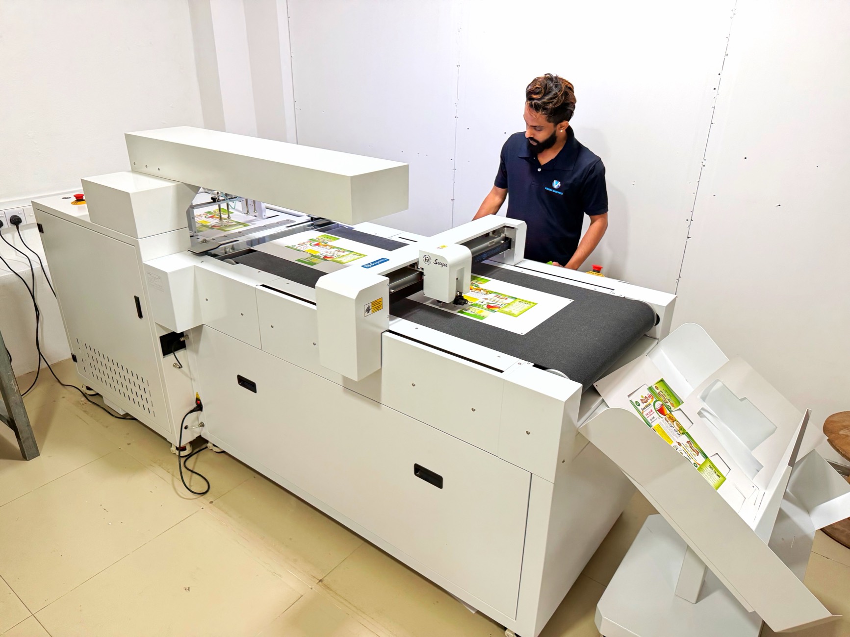 Operator running printed sheets through a digital cutting table